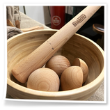 Strumenti in legno per trattamenti manuali professionali, raccolti in una ciotola.