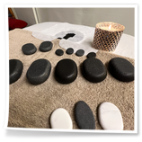 Pietre calde per massaggio Hot Stone preparate sul lettino dello studio Oikia Massaggi.